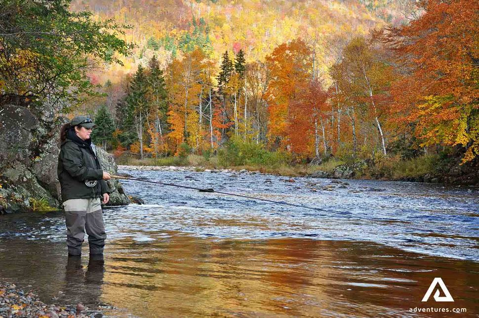 Fishing in the Mabou River A person fishing in the Mabou River surrounded by autumn foliage