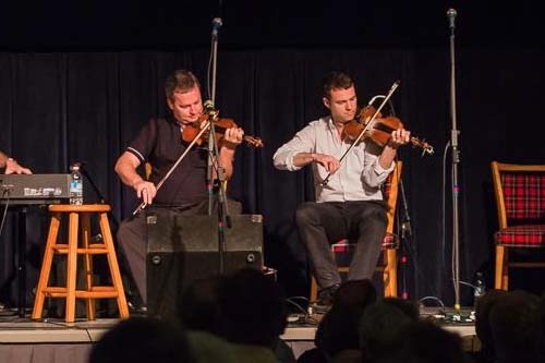 Fiddle Players at KitchenFest Two musicians playing fiddles on stage at KitchenFest